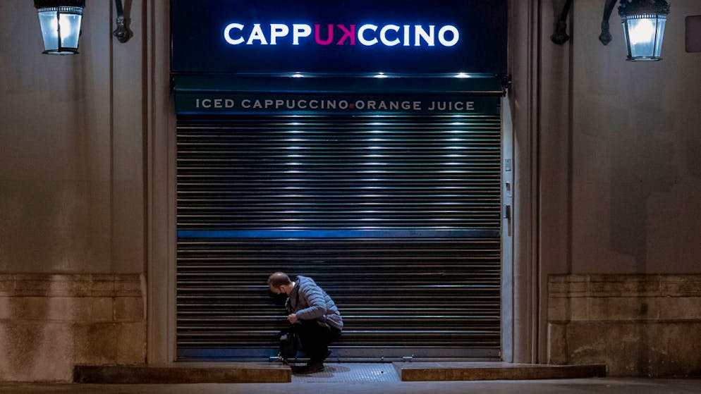 Ein Angestellter schliesst ein Café vor der Sperrstunde in Barcelona.