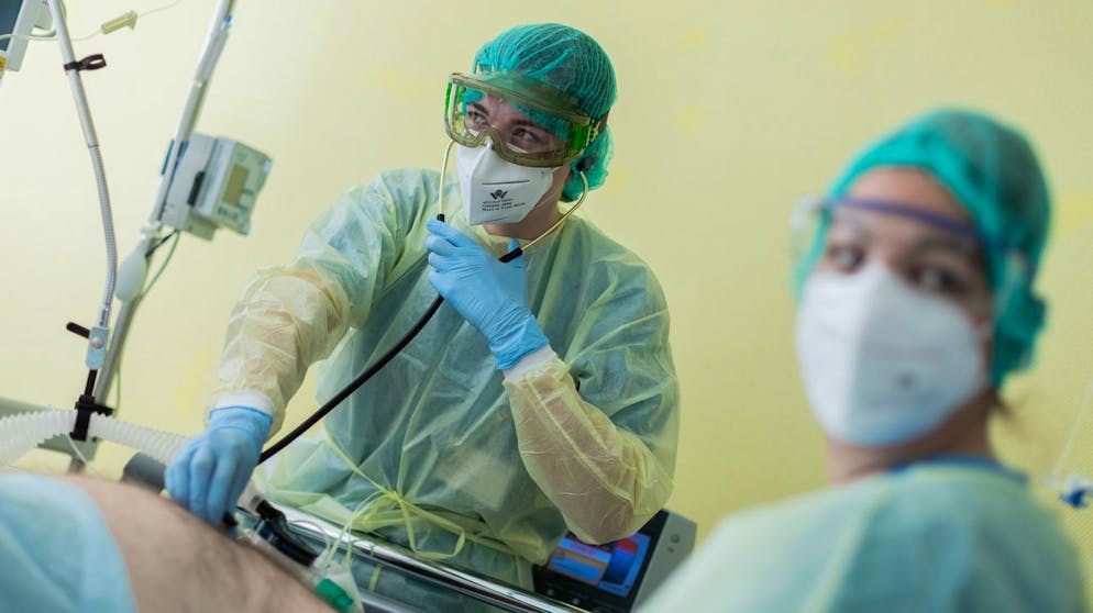 Eine Ärztin im Universitätsklinikum Bonn untersucht am 10. November 2020 einen Corona-Patienten, der beatmet auf einer Intensivstation liegt.