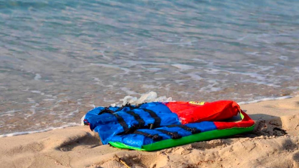 HANDOUT – Eine Rettungsweste liegt am Strand. Beim Untergang eines Bootes mit Flüchtlingen sind vor der Küste im Westen Libyens mindestens 74 Menschen ertrunken. An Bord des Bootes sollen demnach mehr als 120 Menschen gewesen sein, darunter auch Kinder. Foto: Hussein Ben Mosa/IOM 2020/AP/dpa – ACHTUNG: Nur zur redaktionellen Verwendung im Zusammenhang mit der aktuellen Berichterstattung und nur mit vollständiger Nennung des vorstehenden Credits