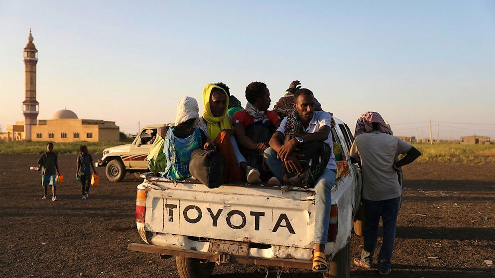 Äthiopische Flüchtlinge sitzen auf der Ladefläche eines Pick-ups. Nach Angaben des UN-Flüchtlingshilfswerks hat der wachsende Konflikt in Äthiopien dazu geführt, dass Tausende aus der Region Tigray in den Sudan geflohen sind. Äthiopiens Militär erhält in seinem Kampf gegen die Volksbefreiungsfront von Tigray (TPLF) nach deren Angaben auch Unterstützung aus Eritrea sowie einem nicht näher bezeichneten Staat ausserhalb Afrikas. Foto: Marwan Ali/AP/dpa