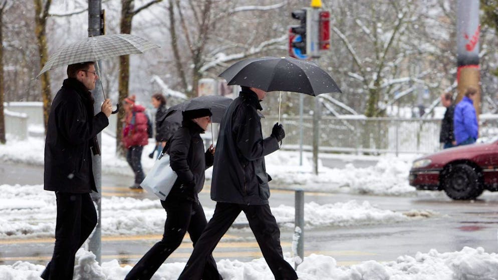 Passanten überqueren im verschneiten Zürich eine Strasse – ein seltenes Bild. (Symbolbild)