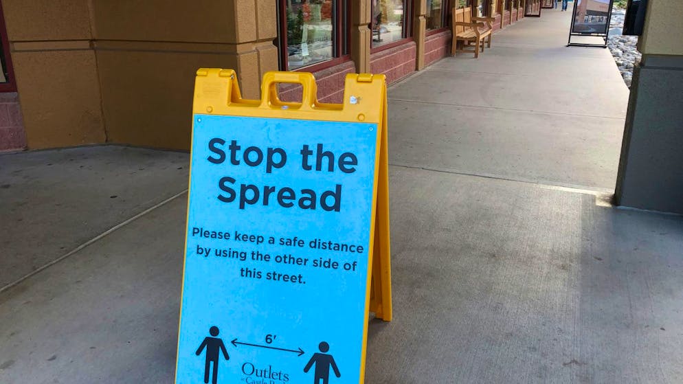 Ein Schild vor einem Einkaufszentrum im US-Bundesstaat Colorado weist Kunden darauf hin, Abstand zu halten, um die Verbreitung des Coronavirus einzudämmen. Foto: David Zalubowski/AP/dpa