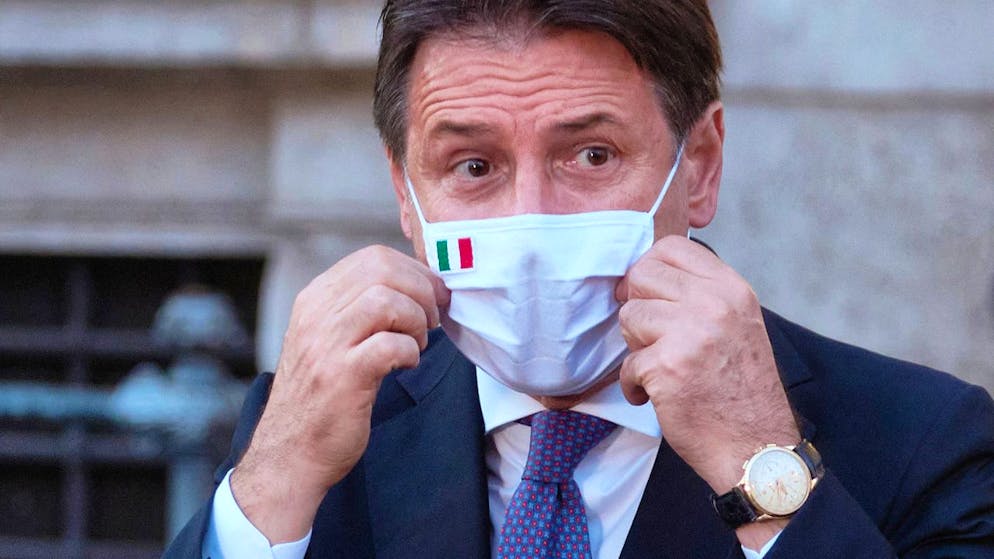 ARCHIV – Giuseppe Conte, Ministerpräsident von Italien, richtet seinen Mund-Nasen-Schutz bei einer Pressekonferenz. Foto: Mauro Scrobogna/LaPresse/AP/dpa