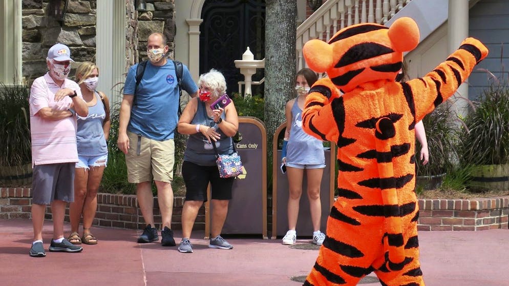 FILE - In this July 11, 2020 file photo, Tigger entertains guests with masks as needed to attend the official reopening day of the Magic Kingdom at Walt Disney World in Lake Buena Vista, Florida.  Walt Disney World announced on Wednesday, October 28, 2020, that more than 700 actors and singers will be fired.  (Joe Burbank / Orlando Sentinel via AP, file)