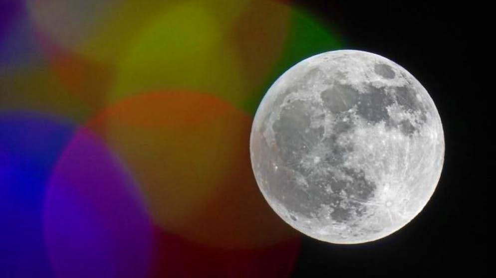 Chi brilla di più?  Una luna piena dietro le luci colorate dell'illuminazione natalizia nel cielo sopra Kansas City, Stati Uniti.  (29.11.2020)