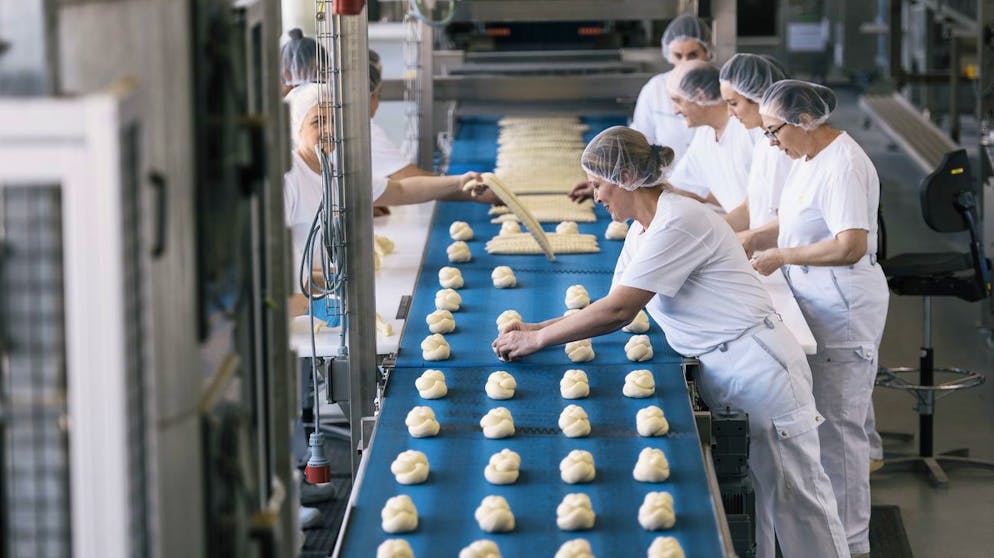 Ein Bild aus Vor-Coronazeiten: Mitarbeitende flechten in der Coop-Grossbäckerei in Schafisheim im Kanton Aargau Butterzöpfe aus vorgefertigten Teigsträngen. (14. März 2018)