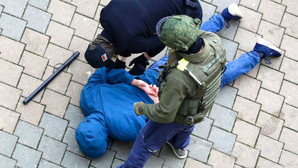Polizisten nehmen während eines Protests der Opposition in Minsk einen am Boden liegenden Mann fest. Foto: ---/AP/dpa