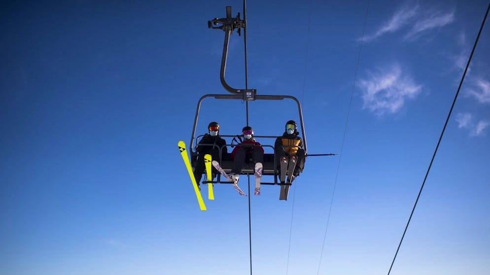 Skifahrer mit Schutzmaske gegen Covid-19, aufgenommen am Sonntag, 29. November 2020, beim "Hoernli" in Arosa. Ab diesem Wochenende gehen einige Lifte vor Ort in den taeglichen Betrieb. (KEYSTONE/Gian Ehrenzeller) Ski enthusiasts with protective face masks enjoy the day, on Sunday, November 29, 2020, in Arosa, Switzerland. Ski resorts in Switzerland are open despite the Covid-19 pandemic. Safety measures are in place. (KEYSTONE/Gian Ehrenzeller)