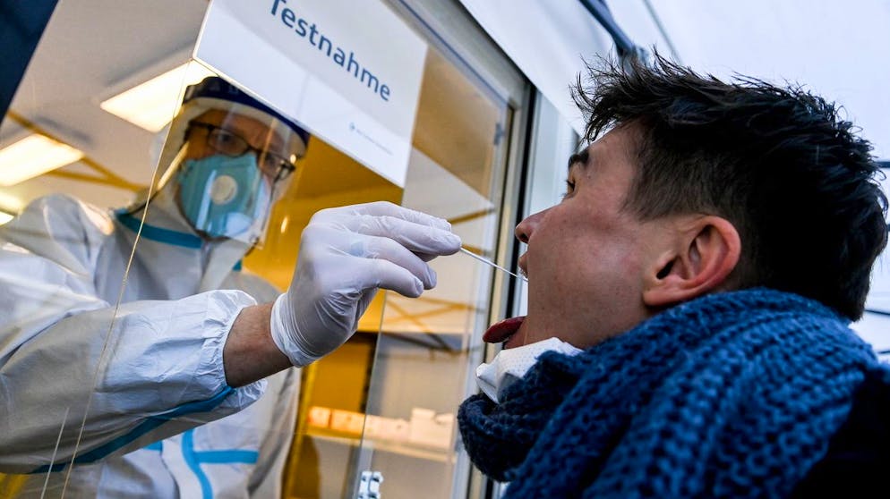 epa08874809 A medical staff takes a swab sample from a visitor to a coronavirus test station Berlin, Germany, 10 December 2020. Health authorities in Germany have reported 23,679 new corona infections to the Robert Koch Institute (RKI) within 24 hours. EPA/FILIP SINGER
