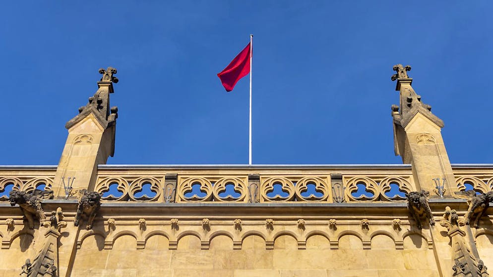 La bandiera rossa che simboleggia il massimo livello d'allerta per il Covid-19 sventola tra la Collegiata e il Castello di Neuchâtel