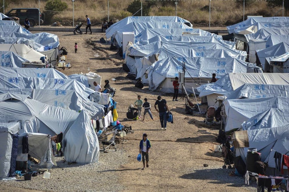 FILE - In this Wednesday, Oct. 14, 2020, file photo, migrants walk after a rainstorm at the Kara Tepe refugee camp, on the northeastern Aegean island of Lesbos, Greece. The anti-torture committee of the Council of Europe, the continent's main human rights organization, on Thursday, Nov. 19, 2020 has slammed conditions under which migrants are held in some detention centers in Greece and voiced concern over persistent allegations the country conducts illegal pushbacks of migrants. (AP Photo/Panagiotis Balaskas, File)