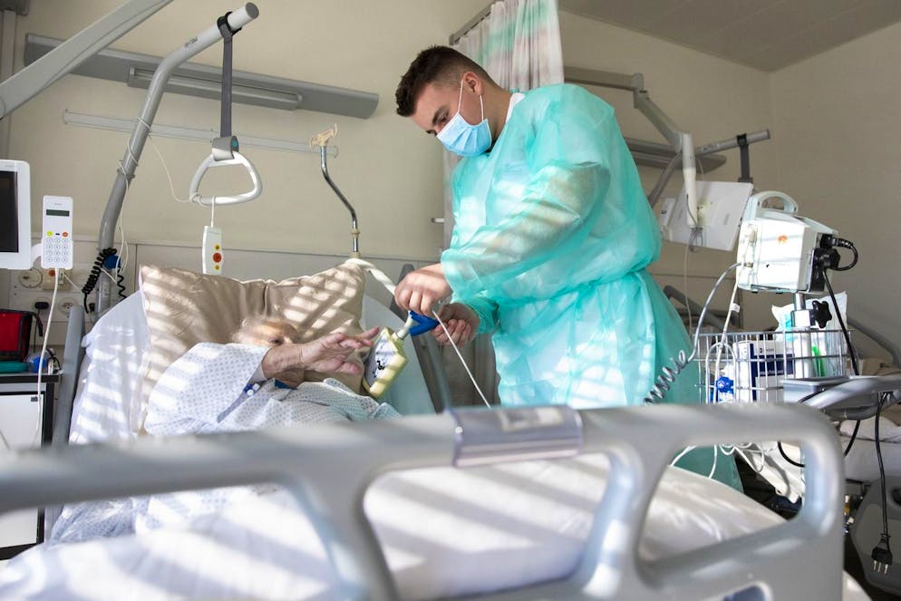 Ein Sanitaetssoldat misst den Blutdruck einer Covid-19 Patientin im Kantonsspital Fribourg HFR, am Donnerstag, 12. November 2020 in Fribourg. Angesichts der sanitaeren Lage und der Zunahme der Fallzahlen am Freiburger Spital HFR, hat das kantonale Fuehrungsorgan von der Armee Unterstuetzung fuer die Pflegeteams des HFR angefordert. Am HFR sind rund 50 Sanitaetssoldaten in einer Rotation rund um die Uhr im Einsatz. (KEYSTONE/Peter Klaunzer)