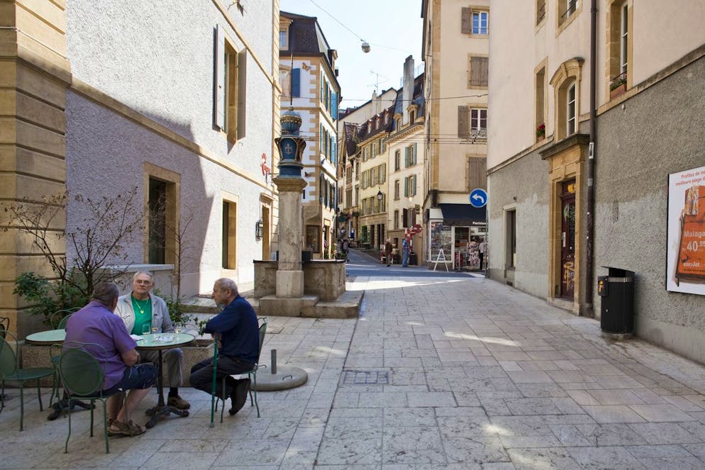 Three men sit with an early glass of white wine in front of brasserie