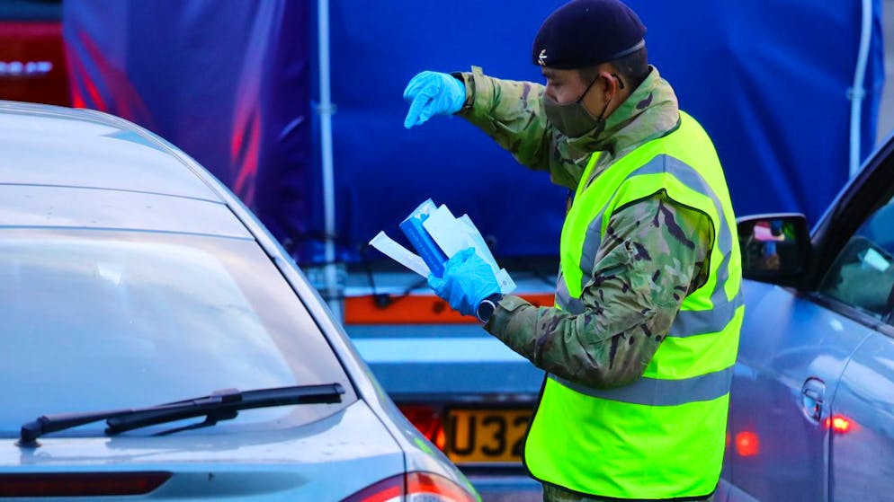 Ein Mann führt einen Corona-Test bei einer im Auto sitzenden Person am Hafen von Dover durch. Die britische-französisch Grenze soll über die Weihnachtsfeiertage offen bleiben und der Verkehr durch den Eurotunnel soll weitergehen. Foto: Aaron Chown/PA Wire/dpa