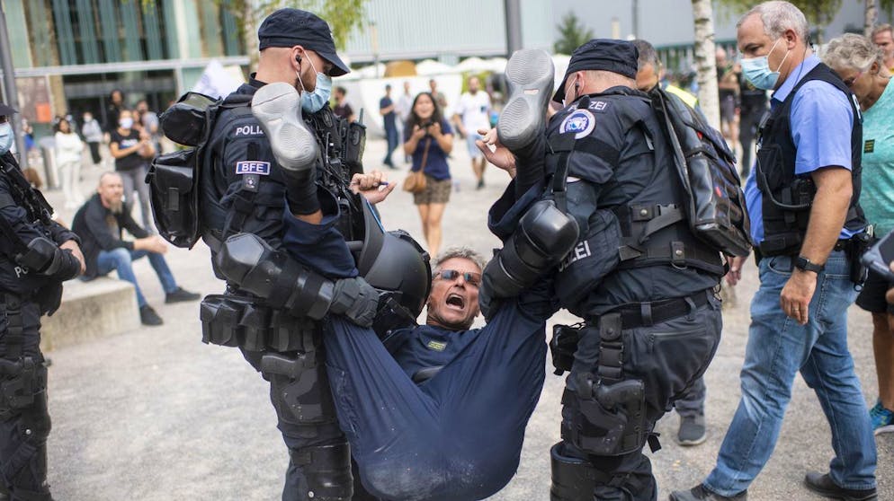 Policemen arrest a demonstrator attends a protest against the Swiss government's measures to slow down the spread of the coronavirus disease (COVID-19), at the Turbinenplatz in Zurich, Switzerland, Saturday, September 19, 2020. (KEYSTONE/Ennio Leanza)