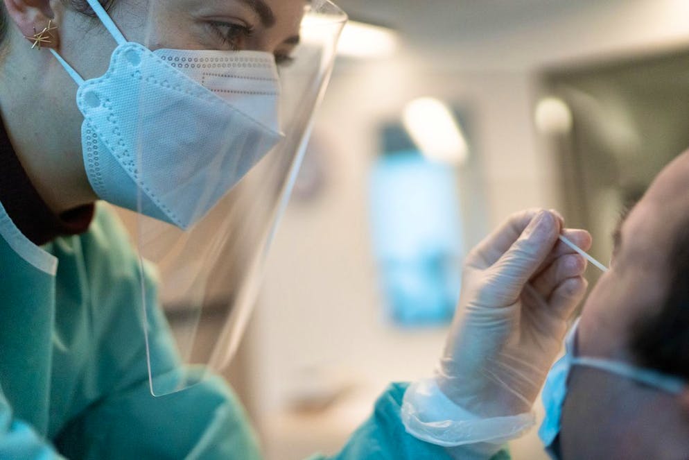 Eine Apothekerin in vorschriftsmaessiger Schutzkleidung macht bei einem Mann einen Abstrich fuer einen Covid-19 Antigen-Schnelltest in der Apotheke TopPharm Apotheke am Paradeplatz am 3. November 2020 in Zuerich. (KEYSTONE/Gaetan Bally)