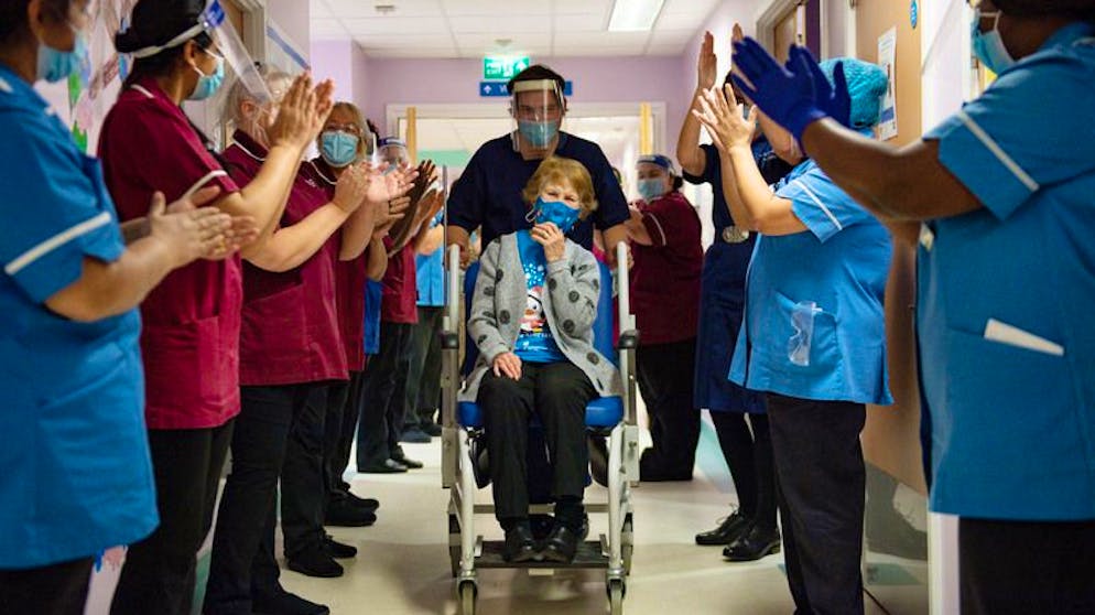 Die 90-jährige Margaret Keenan (M) wird nach der Impfung im Universitätskrankenhaus Coventry von Mitarbeitern des Gesundheitswesens applaudiert.