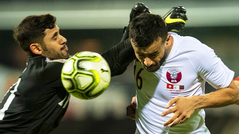 Qatar's Yousef Hassan, left, and Boualem Khoukhi fight for the ball against Switzerland's Mario Gavranovic, right, during an international friendly soccer match between Switzerland and Qatar at the Cornaredo stadium in Lugano, Switzerland, on Wednesday, November 14, 2018. (KEYSTONE/Ennio Leanza)