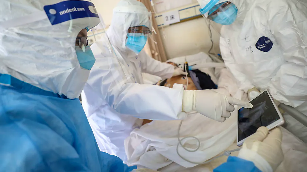 Medizinisches Personal in einem Spital in der chinesischen Stadt Wuhan überprüft den Zustand eines Patienten, der mit dem neuartigen Coronavirus infiziert ist.