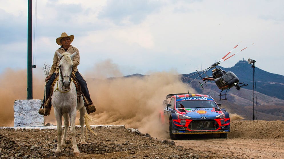 Sportbilder des Tages. Weder das Rally-Auto noch den Hubschrauber scheinen das Pferd zu stören.