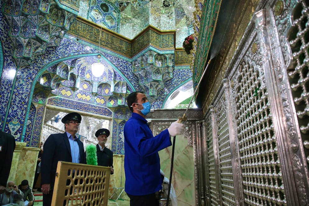 Des travailleurs sanitaires iraniens désinfectent le sanctuaire de Fatima Masoumeh pour empêcher la propagation du coronavirus