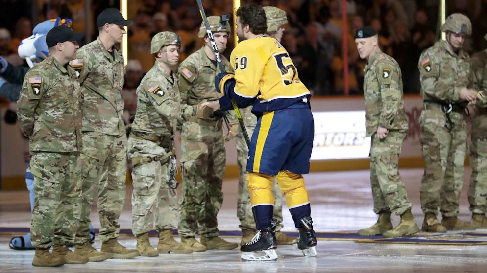 Sportbilder des Tages. Roman Josi bedankt sich bei Angehörigen der US-Armee. Ein Ritual, das in vielen Sportstadien Amerikas zelebriert wird.