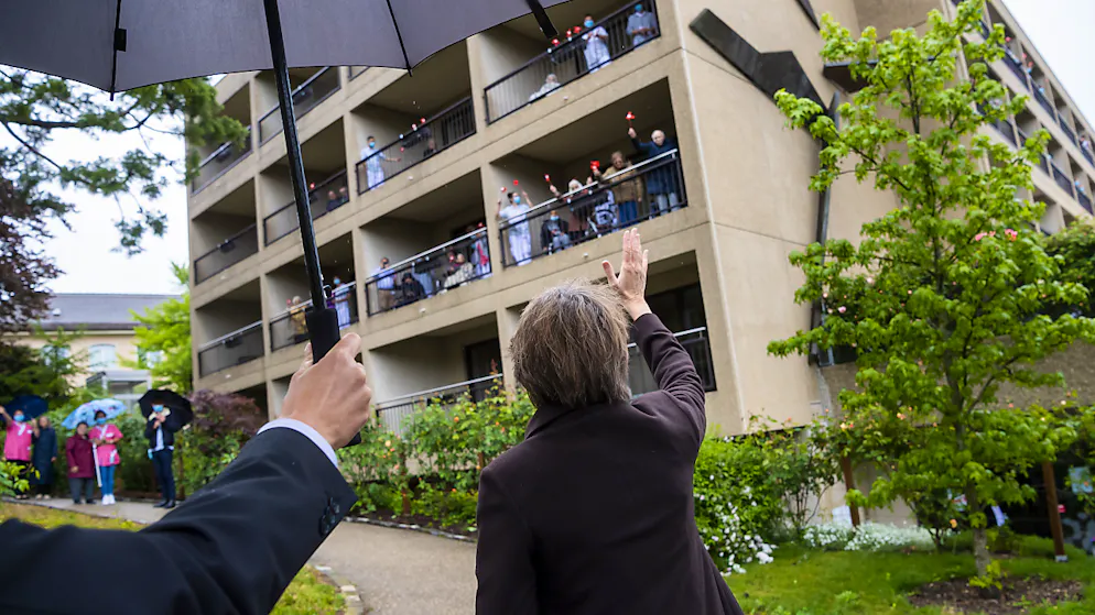 La presidente della Confederazione saluta gli ospiti della casa per anziani, venuti ad accoglierla sui balconi.
