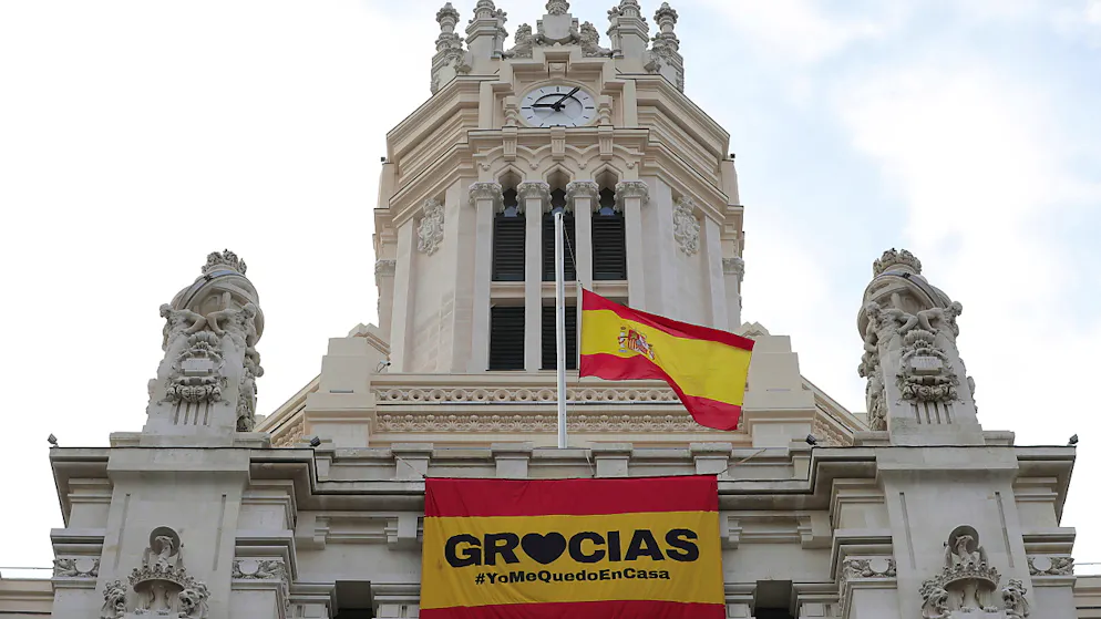 Madrid prevede poi un rimbalzo del Pil del 6,8% nel 2021. Sulla bandiera si può leggere: «Grazie, rimani a casa».