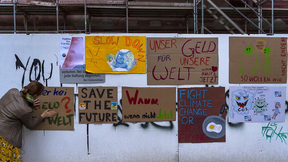 In Basel hängen Plakate von Klima-Aktivist*innen an einer Bauwand.