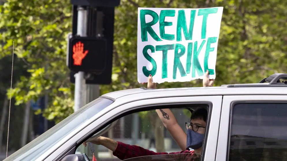 Manifestanti a Los Angeles con un cartello che incita allo «sciopero degli affitti».
