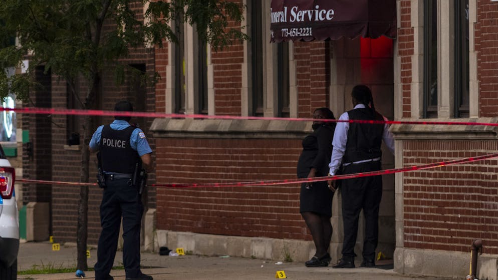 La polizia di Chicago indaga sul luogo della sparatoria, davanti a un'agenzia di pompe funebri.