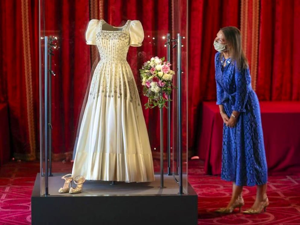 Caroline de Guitut, Kuratorin des Royal Collection Trust, wirft einen Blick auf das Hochzeitskleid von Prinzessin Beatrice. Foto: Steve Parsons/PA Wire/dpa