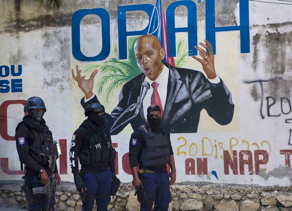 La police se tient près d'une peinture murale représentant le président haïtien Jovenel Moise, près de la résidence du leader où il a été tué par des hommes armés aux petites heures du matin à Port-au-Prince, Haïti, le mercredi 7 juillet 2021.