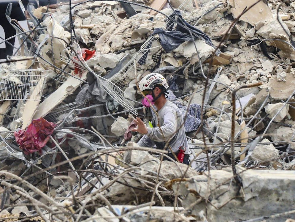A search and rescue team member moves through the debris field of the 12-story oceanfront condo, Champlain Towers South in Surfside, Fla., on Wednesday, July 7, 2021. (Al Diaz/Miami Herald via AP)