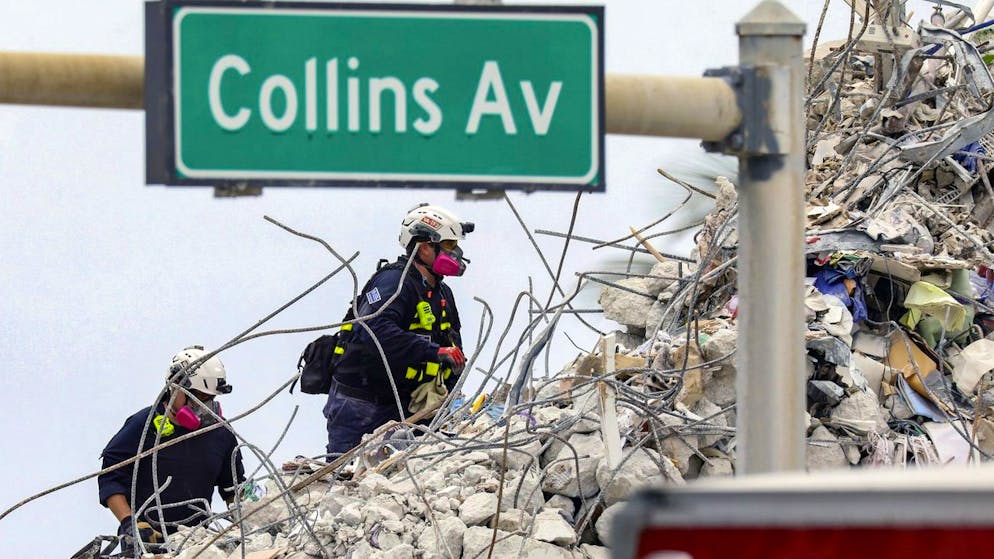 A search and rescue team members climb the rubble of the Champlain Towers South condo, Wednesday, July 7, 2021. (Al Diaz/Miami Herald via AP)