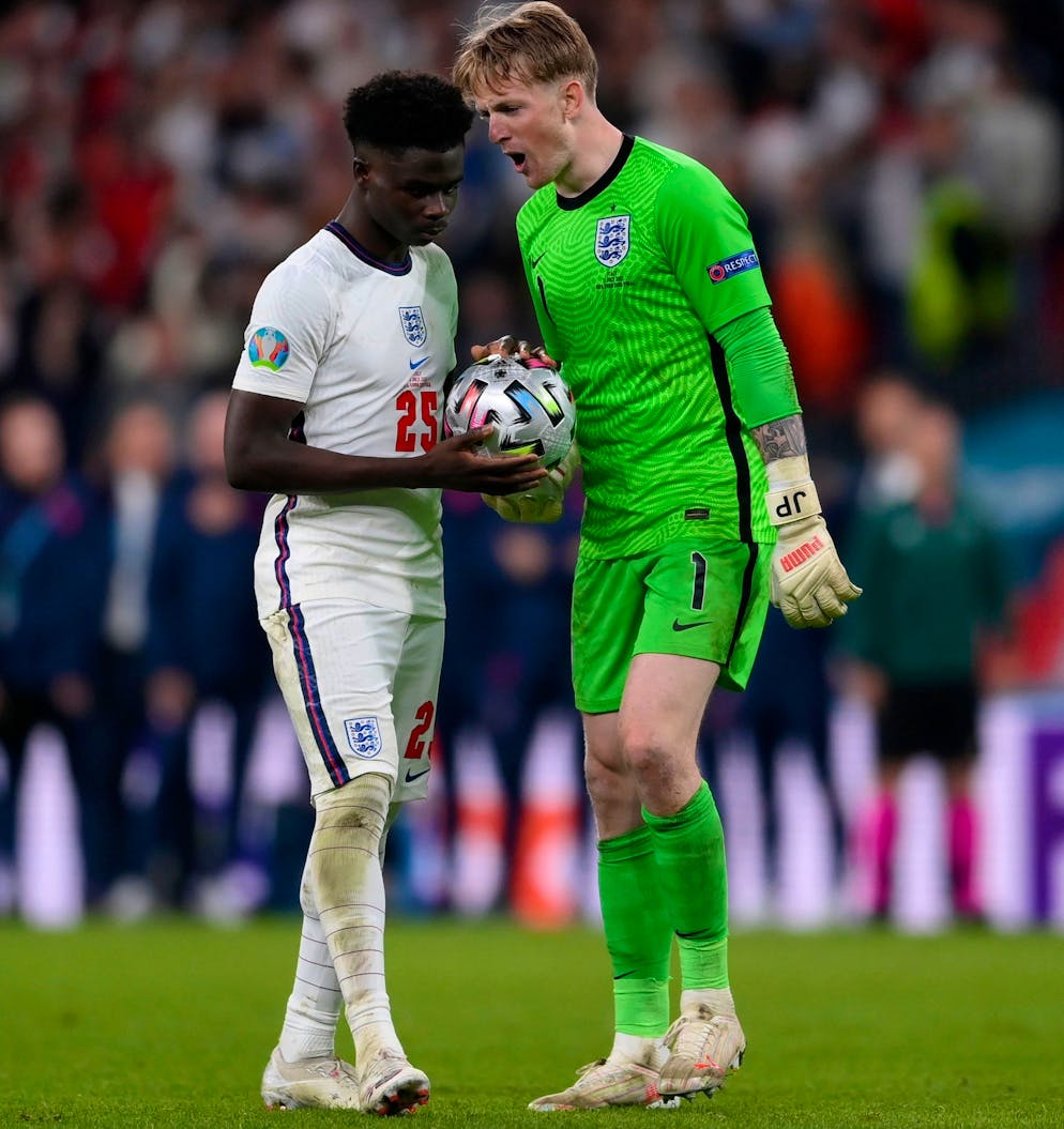 England's goalkeeper Jordan Pickford, right, encourages his teammate Bukayo Saka during the penalty shootout of the Euro 2020 soccer final match between England and Italy at Wembley stadium in London, Sunday, July 11, 2021. (Laurence Griffiths/Pool via AP)