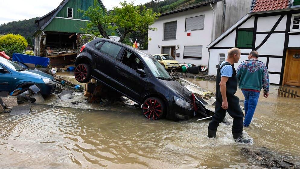 I residenti di Hagen, nel Nord Reno-Westfalia, guardano i danni causati dall'inondazione del fiume Nahmerbach la sera precedente. Le forti piogge hanno trasformato il piccolo fiume in un torrente impetuoso che ha spazzato via auto e case. 