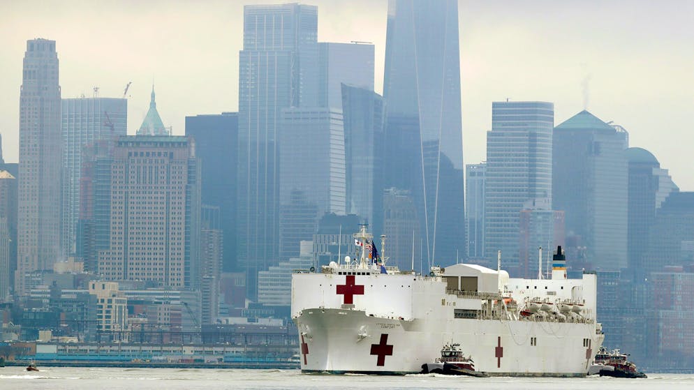 The Navy hospital ship USNS Comfort passes lower Manhattan on its way to docking in New York, Monday, March 30, 2020. The ship has 1,000 beds and 12 operating rooms that could be up and running within 24 hours of its arrival on Monday morning. It's expected to bolster a besieged health care system by treating non-coronavirus patients while hospitals treat people with COVID-19. (AP Photo/Seth Wenig)