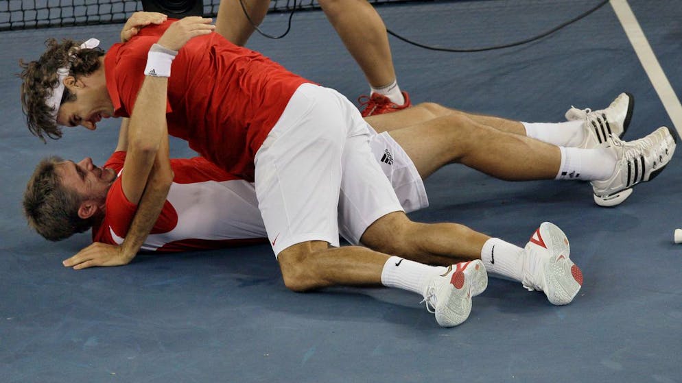 Roger Federer, top, and Stanislas Wawrinka of Switzerland celebrate winning the men's doubles gold medal after defeating Simon Aspelin and Thomas Johansson of Sweden in tennis at the Beijing 2008 Olympics in Beijing, Saturday, Aug. 16, 2008. (AP Photo/Elise Amendola)
