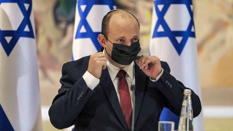 Israeli Prime Minister Naftali Bennett takes off his face mask as he chairs the weekly cabinet meeting at the Knesset in Jerusalem Monday, July 19, 2021. (Gil Cohen-Magen/Pool Photo via AP)