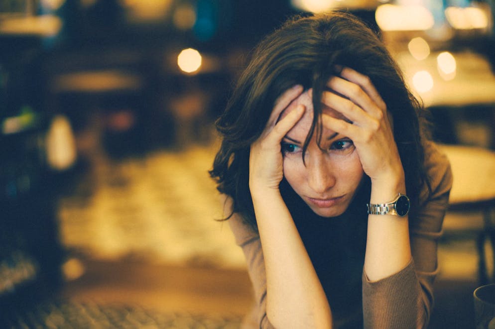 Portrait of a worried woman in cafe bar.