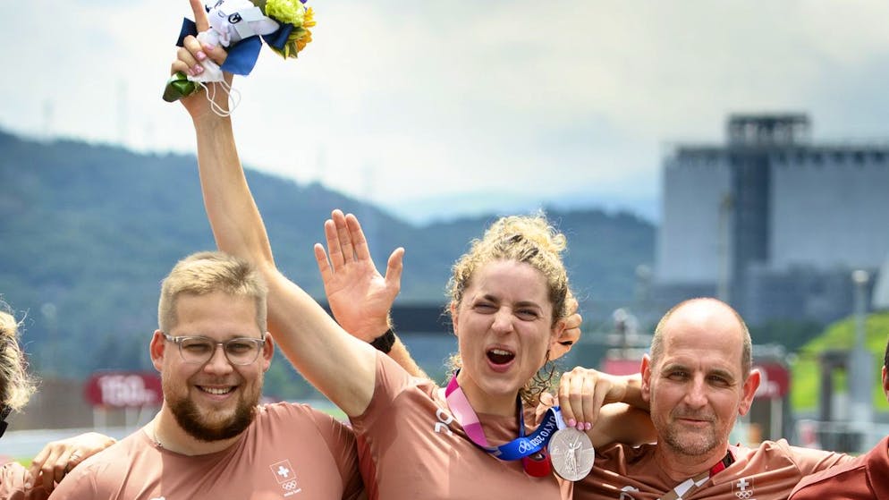 Silver medal winner Marlen Reusser, center, of Switzerland poses for photographer with her national coach Edi Telser, right, and her mechanic Cedric Staehli, left, after the victory ceremony of the women's cycling individual time trial at the 2020 Tokyo Summer Olympics at the Fuji International Speedway, Wednesday, July 28, 2021, in Oyama, Japan. (KEYSTONE/Laurent Gillieron)