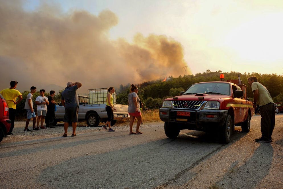 epa09386240 Tourists and residents watch a wildfire in the area of Kalamonas, Rhodes island, Greece, 01 August 2021. Half of the island of Rhodes does not have electricity due to a fire that is in progress in the area Kalamonas. Strong firefighting forces are battling the blaze while the valley of Butterflies and Kalamonas military camp was evacuated for precautionary reasons. EPA/DAMIANIDIS LEFTERIS