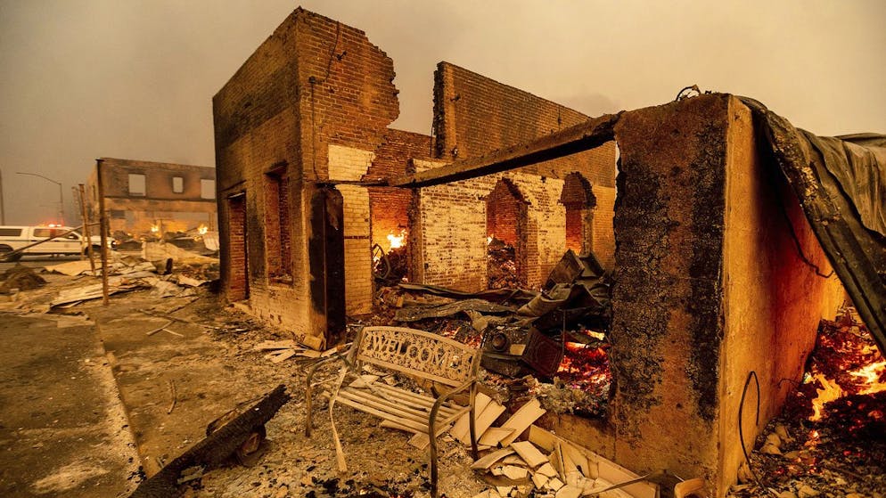 A bench stands outside a scorched building as the Dixie Fire tears through the Greenville community of Plumas County, Calif., on Wednesday, Aug. 4, 2021. The fire leveled multiple historic buildings and dozens of homes in central Greenville. (AP Photo/Noah Berger)