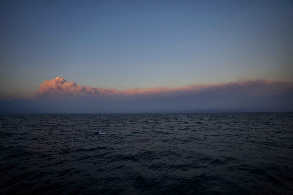Un énorme nuage de fumée remplit les horizons au coucher du soleil sur l'île d'Eubée, où des incendies de forêt catastrophiques continuent de brûler, à environ 160 kilomètres (100 miles) au nord d'Athènes, le samedi 7 août 2021.