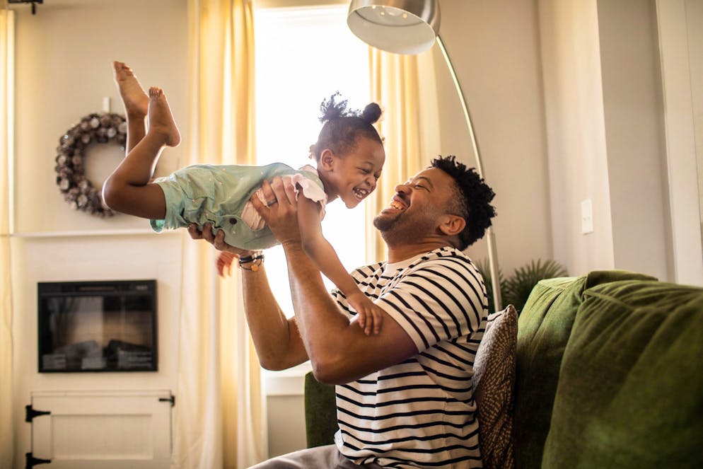 Father lifting toddler daughter in the air