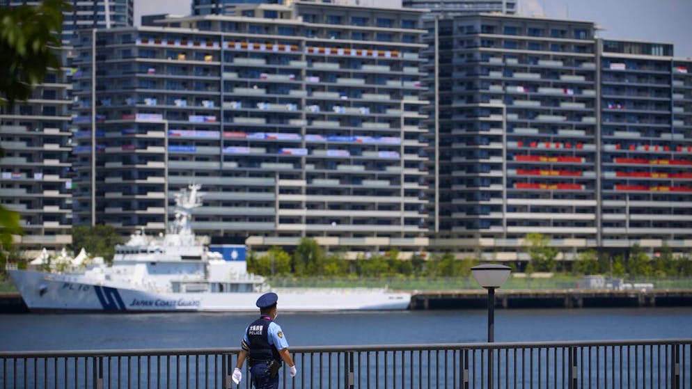 Ein Polizist in Tokio patrouilliert vor dem Olympischen Dorf. 