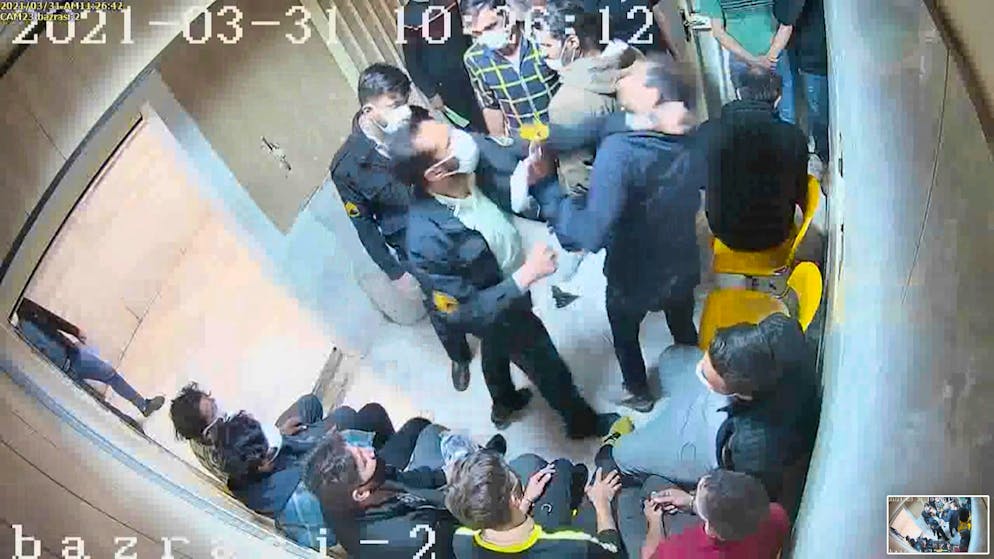 Hier schlägt der Wärter in der Bildmitte mit seiner linken Faust einen Gefangenen.