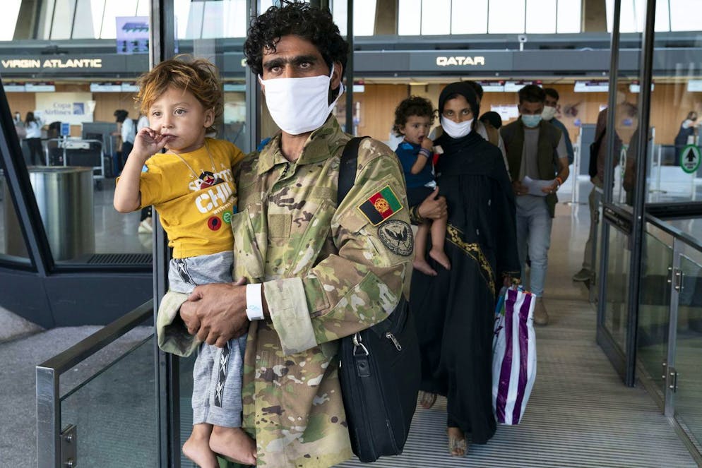 Families evacuated from Kabul, Afghanistan, walk through the terminal before boarding a bus after they arrived at Washington Dulles International Airport, in Chantilly, Va., on Friday, Aug. 27, 2021. (AP Photo/Jose Luis Magana)