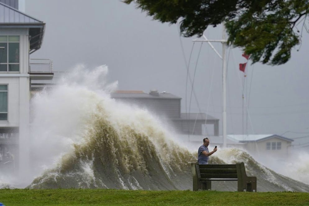 A man takes pictures of high waves along the shore of Lake Pontchartrain as Hurricane Ida nears, Sunday, Aug. 29, 2021, in New Orleans. (AP Photo/Gerald Herbert)